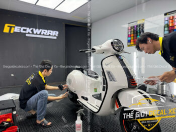 Kỹ thuật viên đang tỉ mỉ dán PPF TPU cho phần hông xe Vespa GTS đảm bảo không lộ mép dán